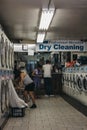 People loading clothes in washing machines inside laundromat in Royalty Free Stock Photo